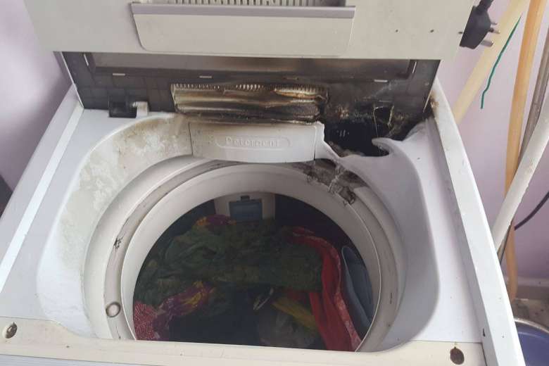 A picture of a defective washing machine that has burn marks on it.